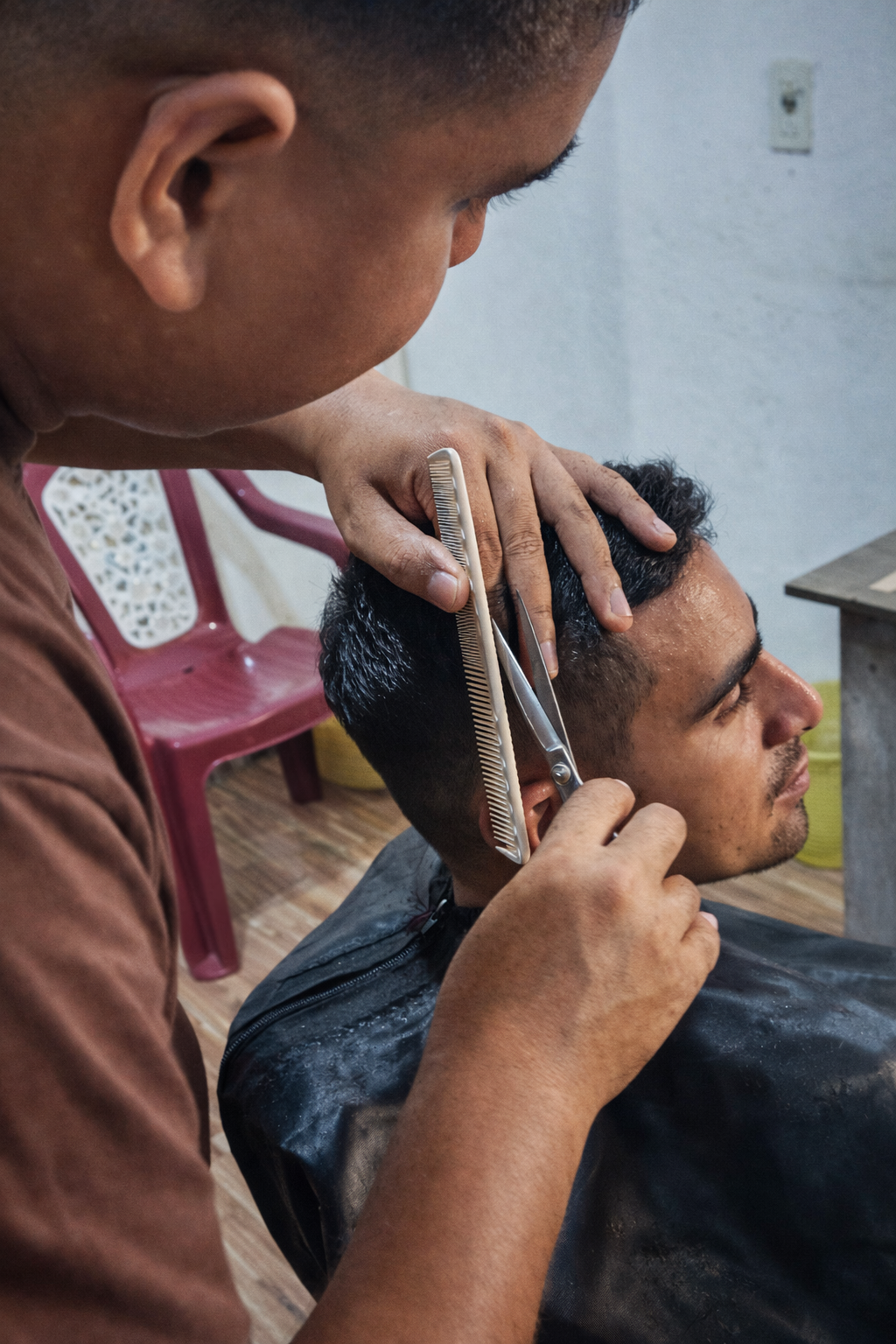 Barbeiro cortando o cabelo de um cliente na Barbearia Benedito